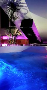 una piscina con iluminación azul y púrpura en una habitación en CANNES TOIT ET MOI en Cannes