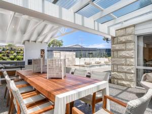 een terras met een houten tafel en stoelen bij Stunning Sorrento Escape With Pool in Sorrento