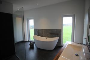 a bath tub in a bathroom with a large window at Modernes Ferienhaus im Schwarzwald in Freiamt +13 photos