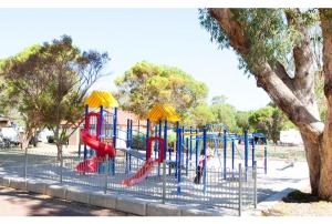 - une aire de jeux dans un parc avec toboggan rouge dans l'établissement Discovery Parks - Woodman Point, à Coogee