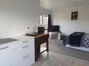 Cette chambre dispose d'un bureau avec un lit et d'un bureau. dans l'établissement Kerikeri Central Apartment, à Kerikeri