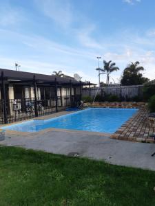 a swimming pool in front of a building at Kerikeri Central Apartment in Kerikeri