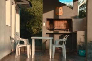 Dos sillas y una mesa en un patio. en La Catalina Traslasierra, en Nono