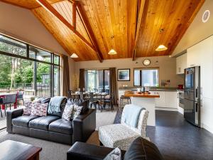 a living room with a couch and a kitchen at Ski Country Chalet - Ohakune Holiday Home in Ohakune