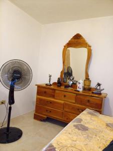 une chambre avec une commode avec un ventilateur et un miroir dans l'établissement Mendez Guesthouse Cottage Montego Bay Villa, à Montego Bay