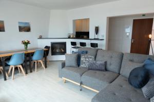 a living room with a couch and a table at Modern appartement met uniek zeezicht in Koksijde