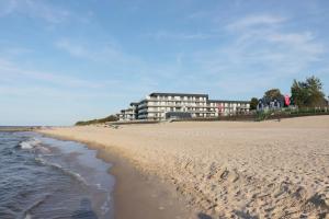 vista su una spiaggia con un edificio sullo sfondo di Apartament MARE - MTN Gardenia Seaside Dziwnów a Dziwnów