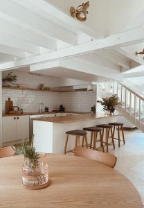 cocina con mesa de madera y algunas sillas en The Loft - beautiful central Barossa apartment, en Tanunda