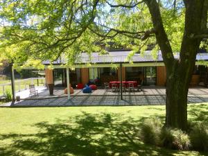 a house with a courtyard with tables and chairs at Korepo Lodge @ Ruby Bay in Nelson