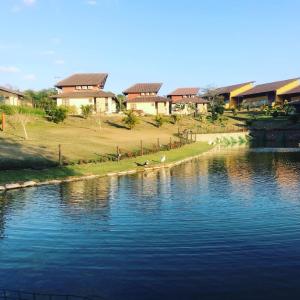 a body of water with houses in the background at FLAT MODERNO E ACONCHEGANTE in Gravatá