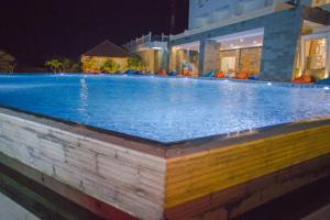 a large swimming pool in a building at night at Pollos Hotel & Gallery in Rembang
