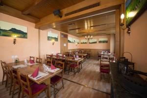 a dining room with wooden tables and chairs at Hôtel - Restaurant Le Manoir in Vaulruz