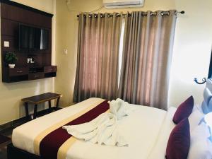um quarto de hotel com uma cama e uma televisão em Hotel the Narayani em Maruwā Ghāt