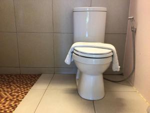 
a white toilet sitting on top of a tile floor at Klong Prao Resort - SHA Extra Plus in Ko Chang
