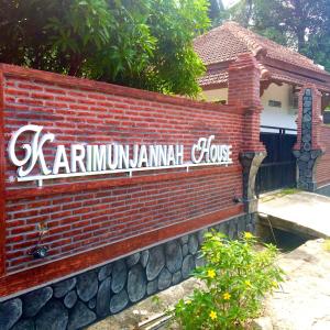 una pared de ladrillo con una señal que lee karnum lanjadote en Karimunjannah House, en Karimunjawa