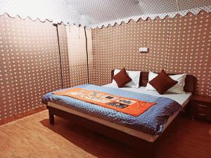 
a bedroom with a bed and a night stand at Vertical Valley Resort in Chakrāta
