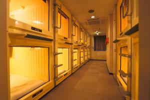 a corridor of a train with many bunk beds at Capsule Land Yushima (Male Only) in Tokyo