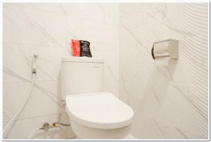 a white toilet in a bathroom with white walls at RedDoorz Plus @ Madukoro Raya Semarang in Kalibanteng-lor