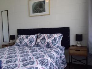 1 dormitorio con 1 cama, 2 lámparas y 1 foto en Fantastic Two Bedroom Unit en Whakatane