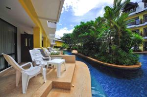 a resort patio with white chairs and a swimming pool at Woraburi Phuket Resort & Spa - SHA Plus in Karon Beach