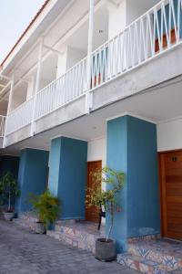 a blue and white building with a staircase at Pemondokan Pratama in Nusa Dua