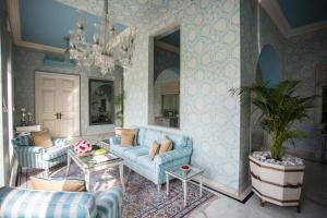 a living room with blue furniture and a chandelier at Rajmahal Palace RAAS in Jaipur