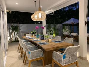 ein Esszimmer mit einem Holztisch und Stühlen in der Unterkunft Villa Serenity Beachfront Bali in Pengastulan