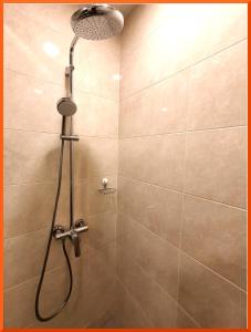 a shower with a shower head in a bathroom at Maple Lodge in Batu Pahat