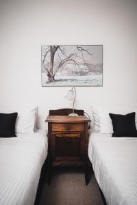 a bedroom with two beds and a table with a lamp on it at Forest View in Castlemaine