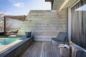 a chair sitting on a deck next to a swimming pool at POD Camps Bay by The Oyster Collection in Cape Town
