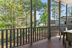 a balcony with a table and chairs and trees at Discovery Parks - Forster in Tuncurry