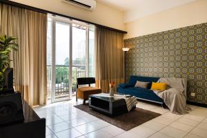 - un salon avec un canapé bleu et une grande fenêtre dans l'établissement Hauzz Seri Bukit Ceylon Residence, à Kuala Lumpur