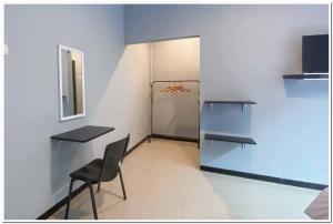 a room with a table and a chair and a refrigerator at RedDoorz Syariah near T2 Juanda Airport 2 in Dares
