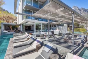 an outdoor patio with a swing and a pool at POD Camps Bay in Cape Town