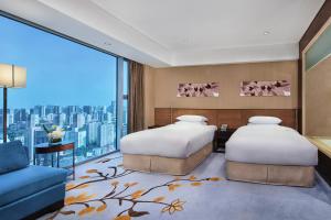 Duas camas num quarto com uma janela grande em Crowne Plaza Beijing Sun Palace, an IHG Hotel em Pequim