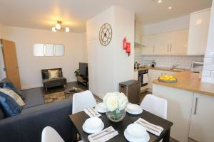 a kitchen and a living room with a table and chairs at Aisiki Living at Upton Rd, Multiple 1, 2, or 3 Bedroom Apartments, King or Twin beds with FREE WIFI and FREE PARKING in Watford