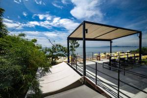 een paviljoen met tafels en parasols op het strand bij Good Living By Veranda Residence Pattaya in Na Jomtien