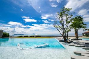 a swimming pool with a tree in the middle at Good Living By Veranda Residence Pattaya in Na Jomtien