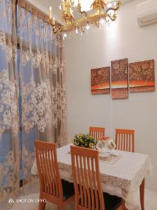 ein Esszimmer mit einem Tisch mit Stühlen und einem Kronleuchter in der Unterkunft 一中太陽綠墅 in Taichung