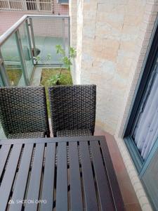 duas cadeiras sentadas em cima de um banco numa varanda em 一中太陽綠墅 em Taichung
