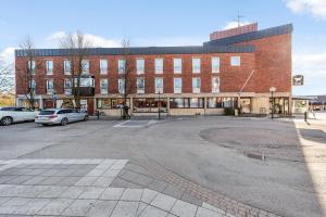 an empty parking lot in front of a brick building at Hotel Oxelösund in Oxelösund