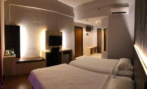um quarto de hotel com duas camas e uma secretária em Garden View Hotel em Bahau