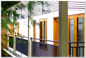 a house with orange doors and a blue railing at RedDoorz Syariah at Omah Sawah in Balong