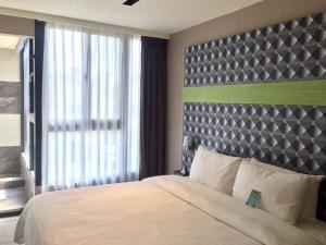 a bedroom with a large bed and a large window at Fengjia Hotel Bell in Taichung