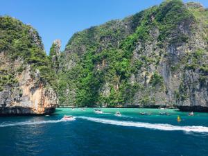 a group of people in boats in the water near cliffs at The Mantra Hotel Kata Noi in Kata Beach