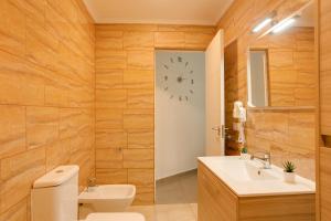 ベシンダリオにある1a Van Halenのバスルーム(トイレ付)、壁掛け時計が備わります。
