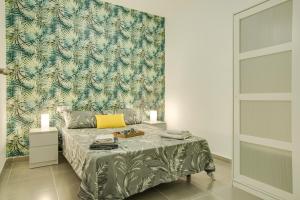 a bedroom with a bed with a tropical wallpaper at 1a Van Halen in Vecindario