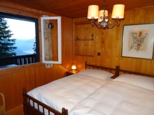 two beds in a room with a window at Rigirolle in Rigi Kaltbad