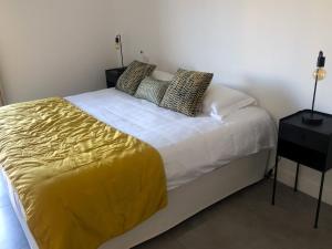 - une chambre avec un lit doté d'une couverture jaune et d'oreillers dans l'établissement Appartement 2 chambres Monte Stella, à Monticello
