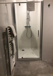 La salle de bains est pourvue d'une douche avec une porte en verre. dans l'établissement Appartement 2 chambres Monte Stella, à Monticello